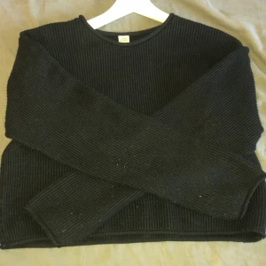 Svart stickad tröja från Uniq Young - Säljer en svart stickad tröja från Uniq Young. Tröjan har rund halsringning och långa ärmar. Den är ribbstickad och har en enkel, klassisk design som passar till mycket. Perfekt för kyligare dagar.