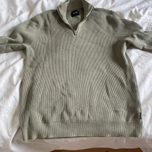 Ljusgrön stickad tröja med quarter-zip från Only & Sons - Säljer en ljusgrön stickad tröja från Only & Sons med halv quarter-zip och hög krage. Tröjan har lång ärm och ribbade muddar, perfekt för lager-på-lager.