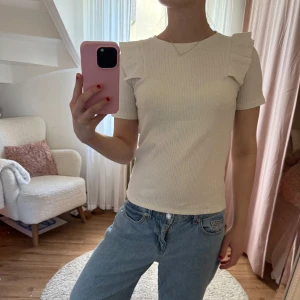 Vit topp med volangdetaljer från Zara - Fin topp från Zara i bra skick! Passar XS-S men är i ganska stretchigt material! Pris går att diskutera🫶