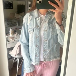 Ljusblå jeansjacka - Säljer en ljusblå jeansjacka från River Island med slitna detaljer och råa kanter. Storleken motsvarar S. Använd max 3 gånger🥰perfekt till vår och sommaren