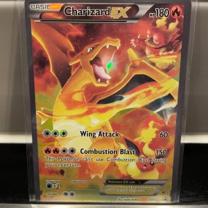 Charizard EX Pokémonkort - Säljer ett Charizard EX-kort från Pokémon TCG, med 180 HP och attacker som Wing Attack och Combustion Blast. Kortet har en färgstark design med Charizard i eldig bakgrund och är från serien XY121.
