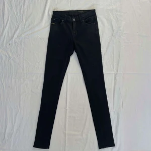 Svarta jeans från Tiger of Sweden - Säljer ett par svarta jeans från Tiger of Sweden. Byxorna har klassisk femficksdesign, smal passform och är tillverkade i ett stretchigt material för extra komfort. Perfekta för en stilren och modern look.