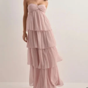 Ljusrosa balklänning  - Helt ny axelbandslös långklänning i ljusrosa med flera lager volanger. Klänningen har smock i ryggen för extra komfort och en flowy siluett. Perfekt för sommarens speciella tillfällen. Fungerar även som balklänning 