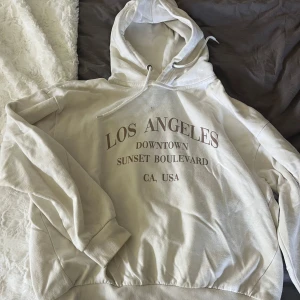 Vit hoodie med Los Angeles-tryck från 157 - Säljer en jätte fin tröja ifrån Lager med text på. Säljer för att den aldrig kommit till användning nu men jag använde den nog en del för flera år sen. Ändå inga defekter vad jag kan se!