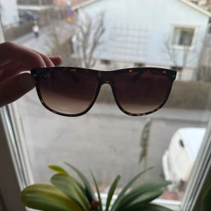 Solglasögon från Ray-Ban - Snygga solglasögon från Ray-Ban med ett klassiskt leopardmönster. De har en stilren design med bruna glas och en robust båge. Perfekta för soliga dagar och kommer med originalpåse. ⚠️påse ingår⚠️
