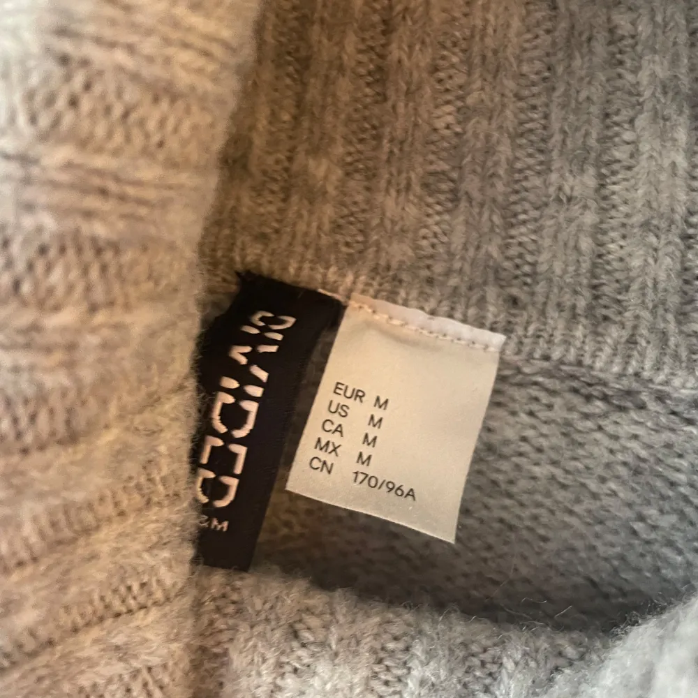 Mysig grå stickad tröja från H&M med kabelstickat mönster framtill. Tröjan har hög polokrage och långa ärmar, perfekt för kyliga dagar. Passformen är lite oversized. Fint skick, storlek M💕. Neuletakit & Villapaidat.