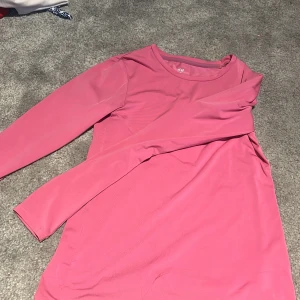 Rosa långärmad tröja från H&M Sport - Säljer en enkel och snygg rosa långärmad tröja från H&M Sport. Klänningen har rund halsringning och är tillverkad i ett mjukt och stretchigt material som passar perfekt för en avslappnad stil.