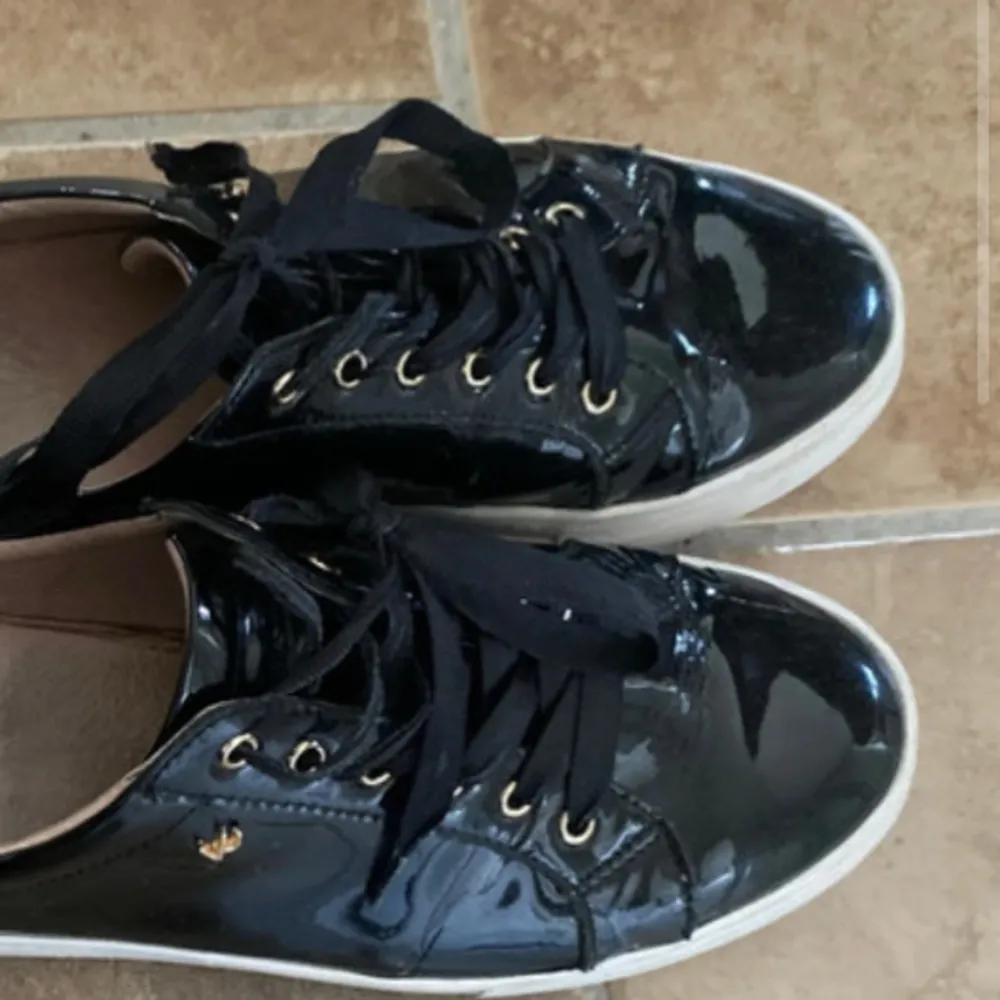 Snygga svarta sneakers i glansigt lack material. Tvättar en extra gång innan jag skickar iväg💕 skriv om ni har frågor!. Kengät.