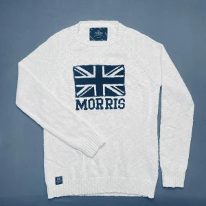 Vit stickad tröja från Morris  - Vit stickad tröja från Morris och texten 'MORRIS' framtill. Tröjan har rund halsringning, långa ärmar och ribbade muddar. Perfekt för dig som gillar klassisk och stilren design.