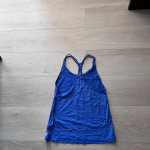 Blå linnetopp med brottarrygg - Säljer en enkel blå linnetopp med brottarrygg. Perfekt för varma dagar eller till träning. Tunt och mjukt material som känns skönt mot huden.