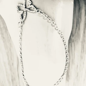 By prisförslag-Armband med fjäril i silverfärg - elegant armband med en detaljrik fjärilsformad dekoration i silverfärg. Kedjan är tunn och smidig, perfekt för att ge en stilren touch till din outfit. Passar dig som gillar diskreta men fina smycken.