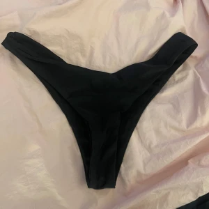 Svarta bikinitrosor - Läs bio! Säljer ett par svarta bikinitrosor med v-formad skärning.  Oanvända. 82% Polyamid 18% Elastan.  Storlek: M Märke: Inte säker men tror TEMU
