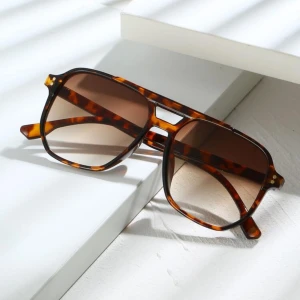 Bruna 🐆 glasögon  - Snygga solglasögon med klassisk aviatorform och leopardmönstrat brunt båge. Glasen är tonade i brunt och bågarna har en modern, oversized look. Perfekt accessoar för att lyfta din stil.