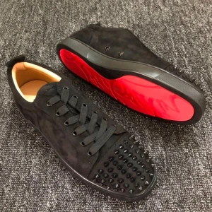 Svarta sneakers med nitar och röd sula - Säljer ett par svarta sneakers med mattsvart mocka och coola svarta nitar på tån. Skorna har snörning och en iögonfallande röd sula undertill. Insidan är ljusbeige och designen är riktigt edgy och modern.