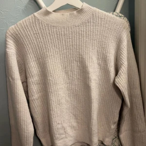 Vit stickad tröja från Uniqlo - Säljer en vit stickad tröja från Uniqlo i storlek M. Tröjan har en klassisk rund halsringning och är ribbstickad för en snygg struktur. Perfekt för kyligare dagar och enkel att matcha med olika outfits.