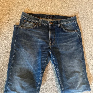 Blå jeans Lean Dean från Nudie Jeans - Säljer ett par klassiska blå jeans från Nudie Jeans, modellen Lean Dean. Jeansen har fem fickor, orangea sömmar och är tillverkade i 99% bomull och 1% elastan för lite stretch. Snygg tvätt och raka ben.