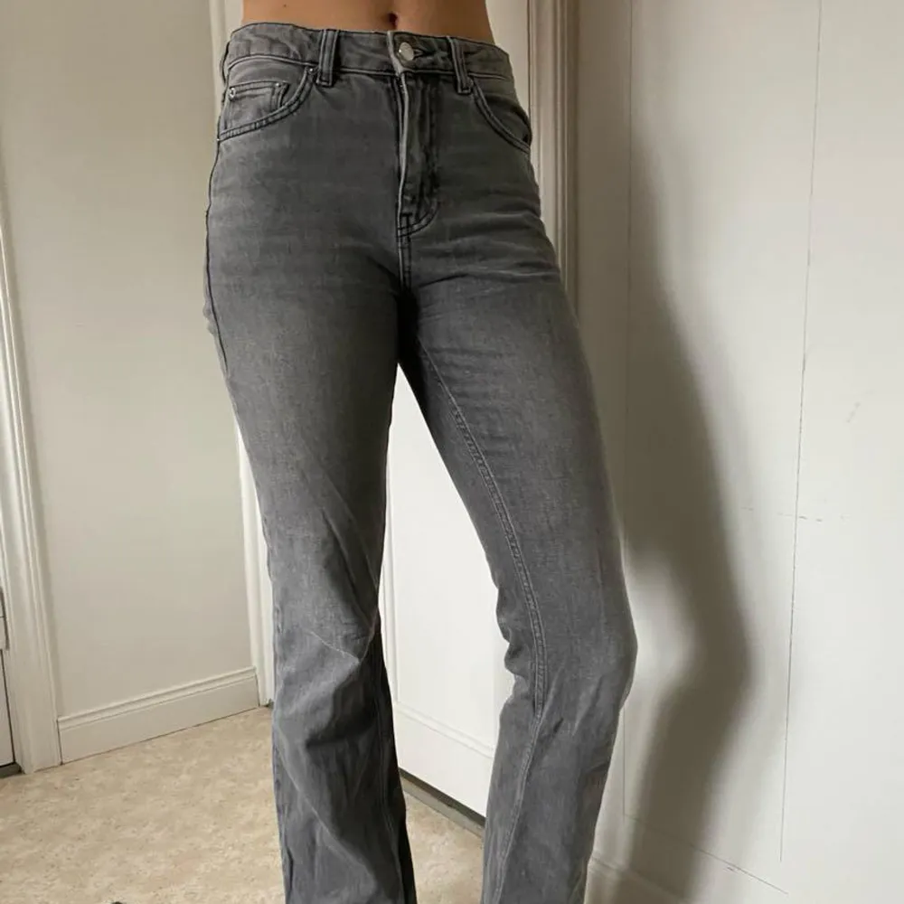 Säljer ett par gråa jeans med bootcut passform och hög midja. Jeansen har klassiska fem fickor och stängs med knapp och dragkedja. Perfekta för dig som gillar en tidlös och enkel stil.. Farkut & Housut.