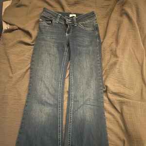 Blå  jeans från Nelly - Säljer ett par klassiska blå jeans från Nelly. Jeansen är i storlek 32 men dom är upp sydda så dom de passar till är 155-160 i längden 
