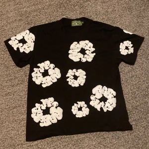 Svart Denim Tears T-shirt  - Denim tears t shirt som jag har använt få gånger. De är väldigt sköna och perfekta för sommaren och back to school.det finns sammma fast shorts i shoppen om ni vill köpa bundle eller bara dom. Vi kör en liten rea nu också för att sommaren är snart slut så passa på. Kolla in shoppen för mer snygga kläder