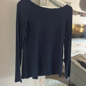 Mörkblå långärmad topp i bomull från Intimissimi  - Snygg mörkblå långärmad topp från Intimissimi med rundad hals. Tillverkad i mjuk och stretchig bomull som känns skön mot huden. Perfekt att matcha med jeans eller kjol för en clean och enkel look. Passar dig som gillar stilrena basplagg.