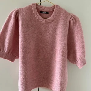 Rosa stickad tröja från Gina Tricot - Superfin ljusrosa stickad tröja från Gina Tricot med puffiga kortärmar och rund halsringning.  köpt för 300, den är nästan aldrig använd.