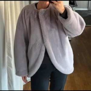 Ljuslila pälsjacka från H&M - Säljer en fluffig och oversized ljuslila pälsjacka från H&M i storlek 36. Jackan har rund halsringning, långa ärmar och är tillverkad i mjukt syntetmaterial som ger en lyxig känsla. Perfekt för dig som vill ha en mysig och trendig look.