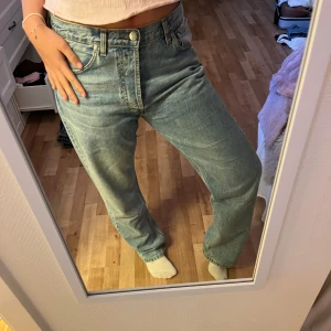 Blå djerf avenue jeans med broderat hjärta  - Säljer ett par blå jeans från Diesel med relaxed passform och raka ben. På bakfickan finns ett broderat rött hjärta och texten Diesel. Jeansen har klassisk femficksdesign, knapp och dragkedja framtill. Perfekt för dig som gillar coola detaljer och skön stil.