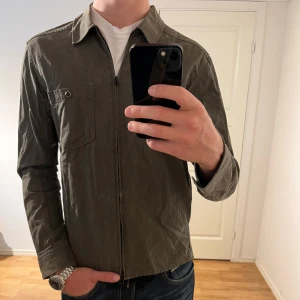 J.Lindeberg Overshirt med dragkedja  - Säljer denna sjukt snygga Overshirten från J.Lindeberg⭐️ Färgen är mörkgrön och storleken är M✅ Overshirten har inga defekter och skicket är utomordentligt🙌🤝 Sjukt najs passform och passar perfekt till hösten🍁🙌 Tveka inte på att höra av er dig vid minsta fråga eller fundering😊