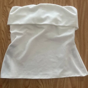 Vit bandeau tubtopp med dragkedja - Säljer en vit bandeau tubtopp med snygg dragkedjedetalj på sidan. Aldrig använt, prislappen är kvar 