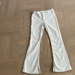 Vita flare jeans från H&M, låg midja - Snygga vita jeans från H&M med flare-ben och låg midja. Modellen är justerbar och man kan spänna in och ut de i midjan. Materialet är mjukt och bekvämt bomullstyg. Och de är såklart tvättade. Storlek 140