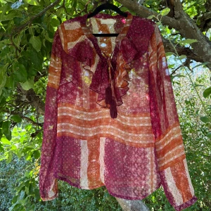 Cream blus  - Otroligt vacker blus från märket Cream i storlek 40. Färgen är en superfin mörkare röd men detaljer i orange och beige. Mycket fint skick, jag hittar inga synliga anmärkningar eller defekter. Den kan vara något transparent. 