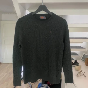 100% Merinoull mörkgrön stickad tröja Morris  - Säljer en mörkgrå stickad tröja från Morris i storlek XXL men krympt till runt S-XS tillverkad av 100% merinoull. Jätte najs, slim fit sitter riktigt bra. Sljer eftersom den blivit för liten för mig. 