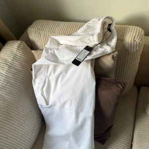 Vita cargopants med elastisk midja - Snygga vita cargopants från Parajumpers med elastisk midja och praktiska fickor på sidorna. Byxorna har en clean look och är gjorda i mjukt bomullsmaterial som känns skönt mot huden. Perfekt för dig som gillar streetstyle och vill ha något fräscht i garderoben.