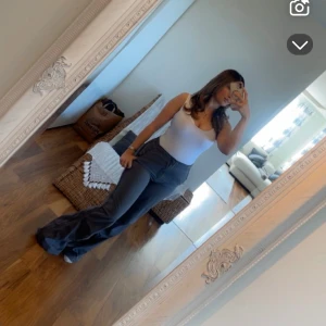 Grå wide byxor med resårmidja - Säljer ett par gråa byxor med breda ben och resår i midjan. De har en loose passform och är tillverkade i ett mjukt syntetmaterial som känns skönt mot huden. Perfekta för en chill och avslappnad stil. Fickor på sidorna för extra funktion.