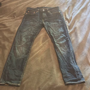 Levi's 502 Premium jeans blå W32 L32 - Snygga Levi's 502 Premium jeans i mörkblå denim med klassiska fem fickor och kontrastsömmar. Modellen har rak passform och normal midja, perfekt för dig som gillar en clean och tidlös look. Levi's patch bak och röd etikett vid fickan.