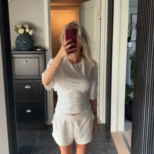 Vit topp - Säljer denna populära och superfina vita topp med knutte i ryggen.