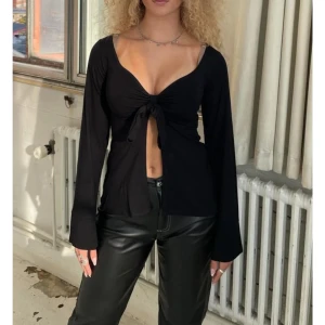 Svart långärmad knytblus - Säljer min fina svarta design by si knytblus! Använd ett par gånger men ej längre därför säljer jag den🥰 Använd men inte tecken på användning. Kom privat för personliga bilder