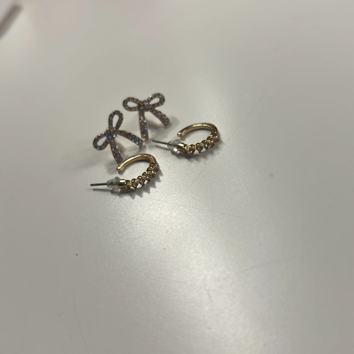 Två par glittriga örhängen i guld