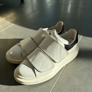 Alexander McQueen vita sneakers med kardborre - Säljer mina chunky vita sneakers från Alexander McQueen med breda kardborreband och mocka baktill då de tyvärr inte kommer till användning längre💕modellen säljs inte längre. Nypris 4500🥰