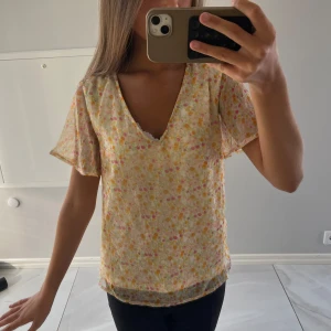 Gul/rosa blommig blus - Supervacker och trendig blus med blommigt mönster som passar perfekt till speciella stunder! Endast använd ett fåtal gånger och är i storlek xs 🩷