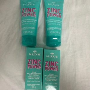 Nuxe Zinc Power rengöring & serum - Säljer två tuber Nuxe Zinc Power Purifying Cleansing Gel och två förpackningar Zinc Power Blemish and Spot Control Serum. Alla produkter är i turkos förpackning med rosa text och innehåller zink, PCA och litchi. Perfekt för dig som vill ha fräsch och klar hud.