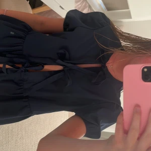 Mörkblå blus med knyt och volanger - Supersöt mörkblå blus med korta puffärmar! Nyskick!