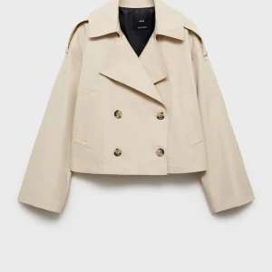 Beige croppad trenchcoat från Mango - Snygg croppad trenchcoat i beige från Mango. Jackan har dubbelknäppning framtill, bred krage och långa ärmar. Perfekt för vår och höst när du vill ha en stilren och trendig look.