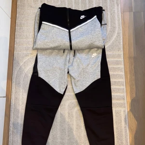 Helt nytt Nike Tech Fleece i grått och svart.  - Säljer Nike Tech Fleece i grått och svart. Helt nya men hann inte lämna tillbaka dem,  passade inte så därför säljer jag. Pris kan diskuteras 