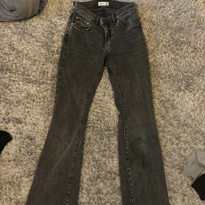 Grå bootcut jeans - Snygga grå jeans med bootcut passform och klassisk femficksdesign. Jeansen är low i midjan och är bootcut. Perfekta för en trendig look.
