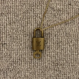 Louis Vuitton lås - Hänglås, ”padlock”,  från Louis Vuitton som kan användas till halsband eller väskor. Går ej att öppna.