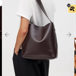 Mörkbrun axelväska med bred rem - Snygg mörkbrun axelväska i slätt skinn med bred justerbar rem och magnetlås. Väskan har ett stilrent och minimalistiskt utseende med innerfack och dragkedja för extra förvaring. Perfekt för dig som gillar klassisk och enkel design. Helt ny med prislapp, aldrig använd. Nypris 499, säljer för 350