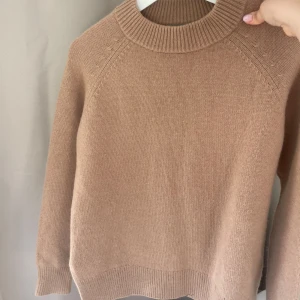 Beige kashmirtröja från H&M - Supermjuk beige stickad tröja från H&M premium selektion. i 100% kashmir. Klassisk modell med rund halsringning och ribbade muddar vid ärmslut och nederkant.