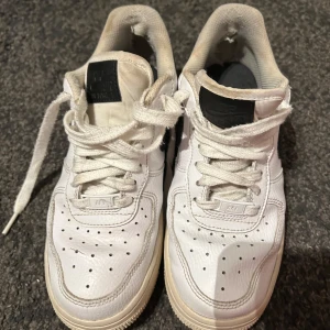 Air force 1 - Klassiska Air Force 1 – den tidlösa sneakerfavoriten från Nike! Med sin enkla och stilrena design passar dessa vita läderskor till nästan allt. Perfekta för både vardag och som en del av din streetwear-look. Den hållbara gummisulan ger bra grepp och komfort hela dagen. 