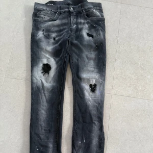 Dondup George jeans  - Säljer ett par svarta Dondup jeans i storlek 34. Byxorna kommer med slitnings från fabrik.        Nypris: 36000.                                                              Väldigt fint skick (9/10) då de är använda endast fåtal gånger! 